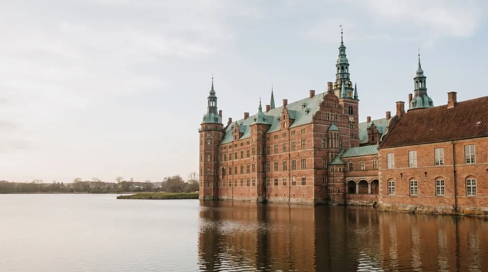 Frederiksborg Slot i røde mursten, der spejler sig i slotssøen i Hillerød
