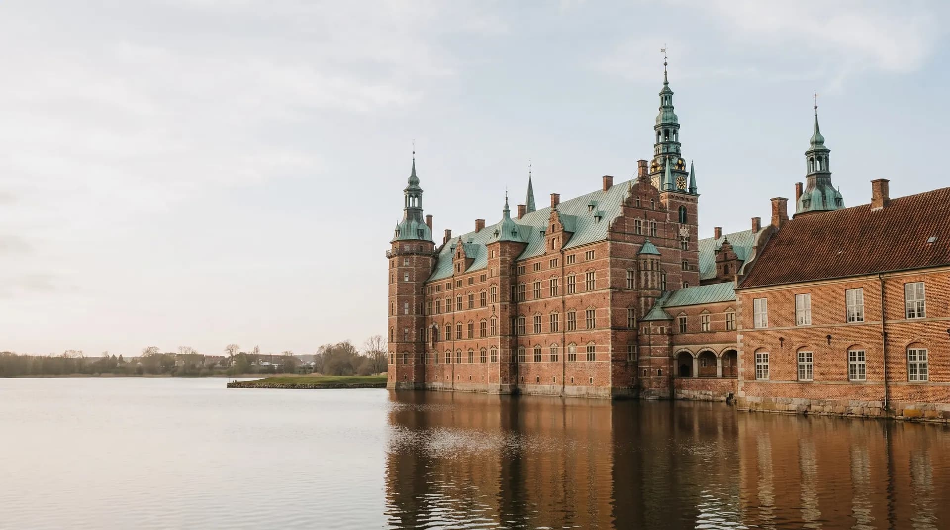 Frederiksborg Slot i røde mursten, der spejler sig i slotssøen i Hillerød