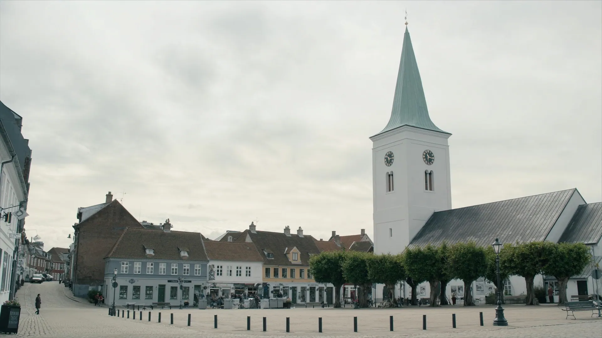 Torvet i Horsens med den hvide kirke, de brostensbelagte flader og rækken af klippede lindetræer