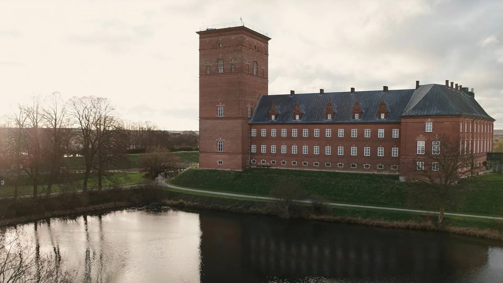 Koldinghus i røde mursten med det høje tårn, set hen over Slotssøen